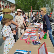 Сотрудница библиотеки Н.С. Грановесова рассказывает посетителям об экспонатах выставки.